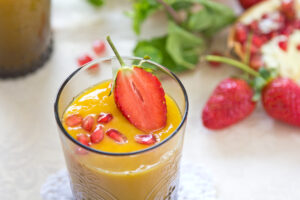 Smoothie mit Mango, Erdbeeren und Granatapfelkernen