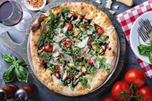 Pizza mit Tomaten, Rucola und Parmezzano