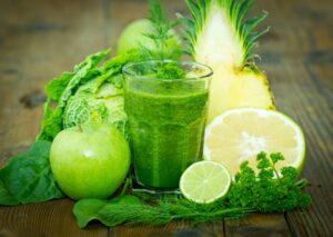 Grüner Smoothie mit Ananas, Apfel, Orange, Wirsing und Limettensaft