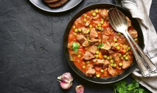 Kalbseintopf mit Erbsen, Paprika und Möhren in Tomatensauce