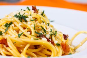 Pasta mit getrockneten Tomaten, veganem Feta und grünem Salat