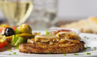 Schweinesteak mit Röstzwiebeln, Tomaten und Oliven