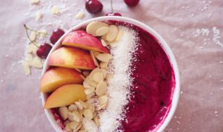 Smoothie-Bowl mit Himbeeren, Kirschen, Nektarine, Mandeln und Kokos